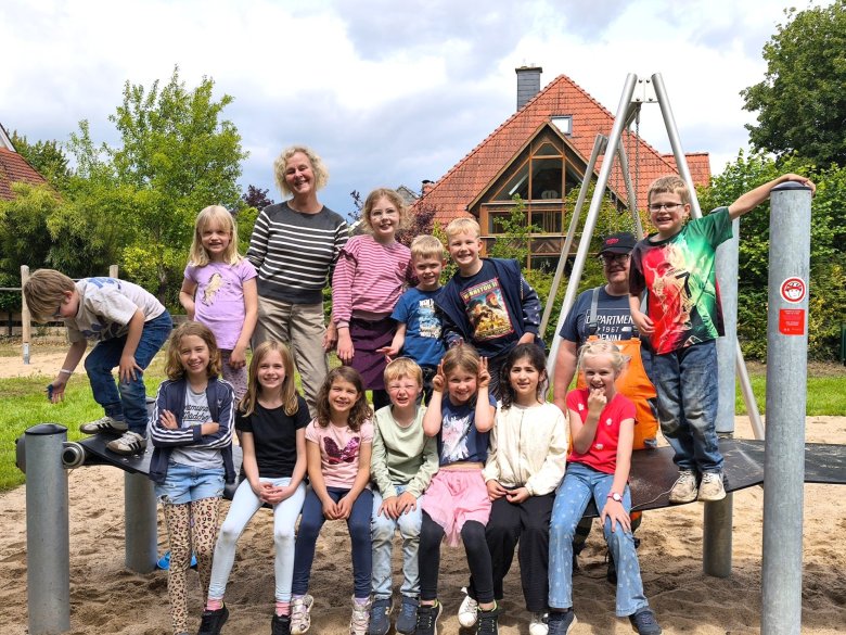 Die Kinder aus der Nachmittagsbetreuung auf dem Spielgerät „Gurtband“ mit den Gemeindemitarbeitenden Julia Tscheslog (3. von links oben) und Frank Hille (2. von rechts).
