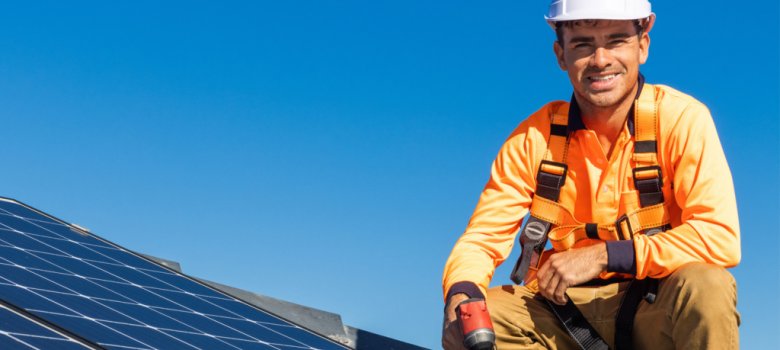 Arbeiter auf Dach mit Photovoltaik-Platten